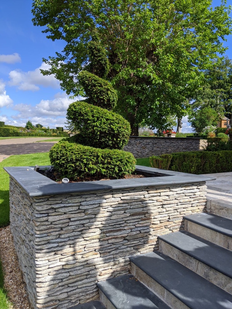 Paddlestone walling with natural slate coping stones