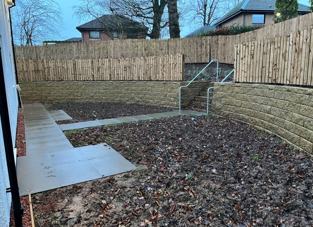 curved retaining wall with wooden fence on top