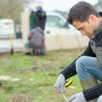 landscaping site visit - male landscaper taking measurements