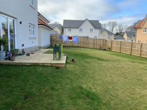 View along width of medium sized newbuild garden with small patio and large lawn