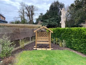 wooden arbour seat in back garden